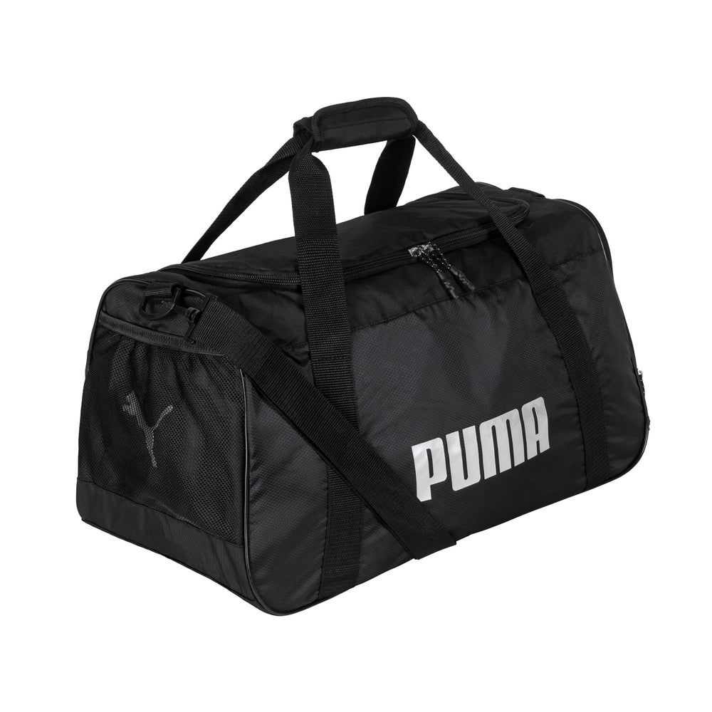 Angle view of a black duffle bag called Foundation by Puma on white background, showing its top handles, side mesh pocket, top zipper compartment and shoulder strap with the Puma logo printed in front.