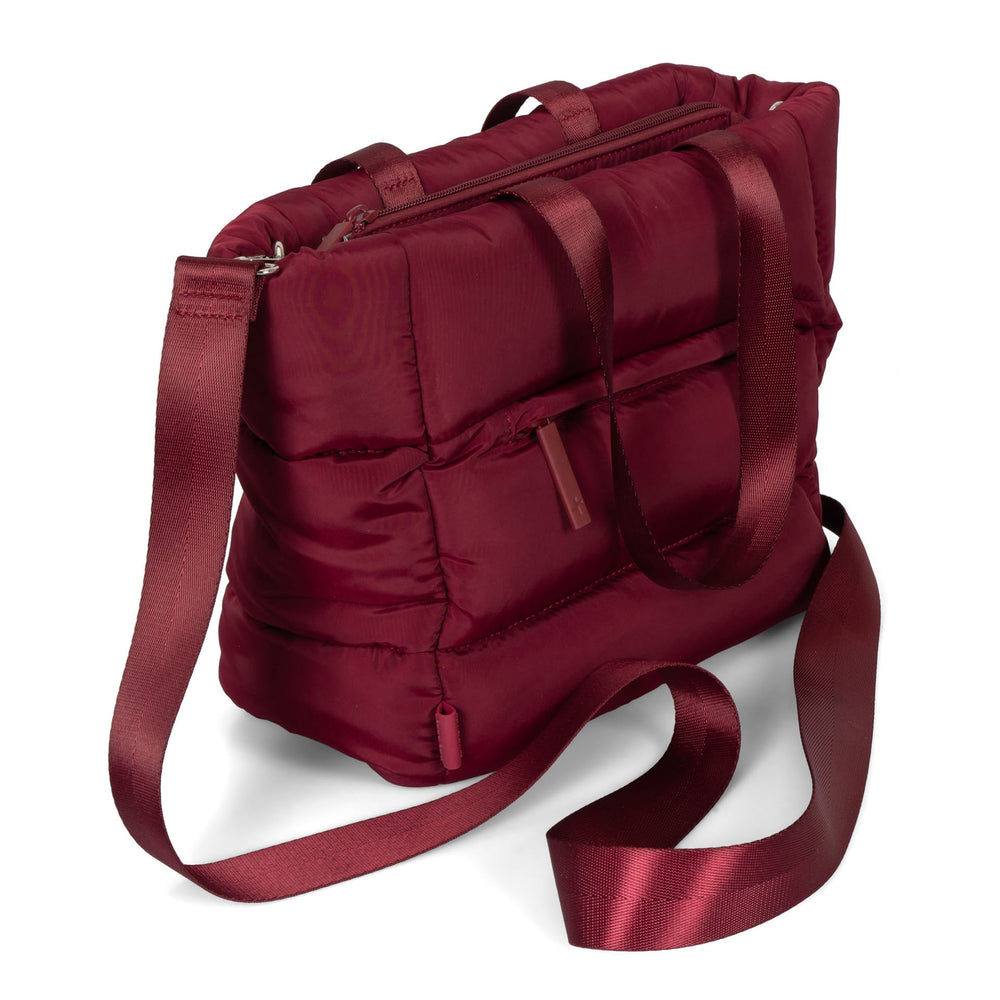 Angle view of a red lunch tote bag called Urban Quilted designed by Tracker on a white background, showcasing its shoulder strap.