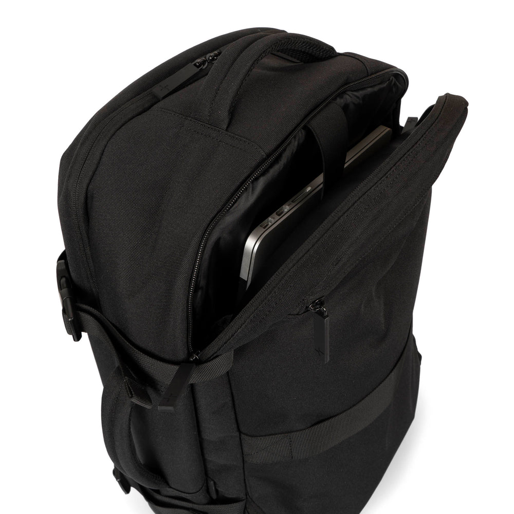 Interior over head view of a black backpack called West Bay 3.0 Convertible designed by Tracker showing its open laptop compartment, top handle, back side pocket, main compartment, side handle and more.