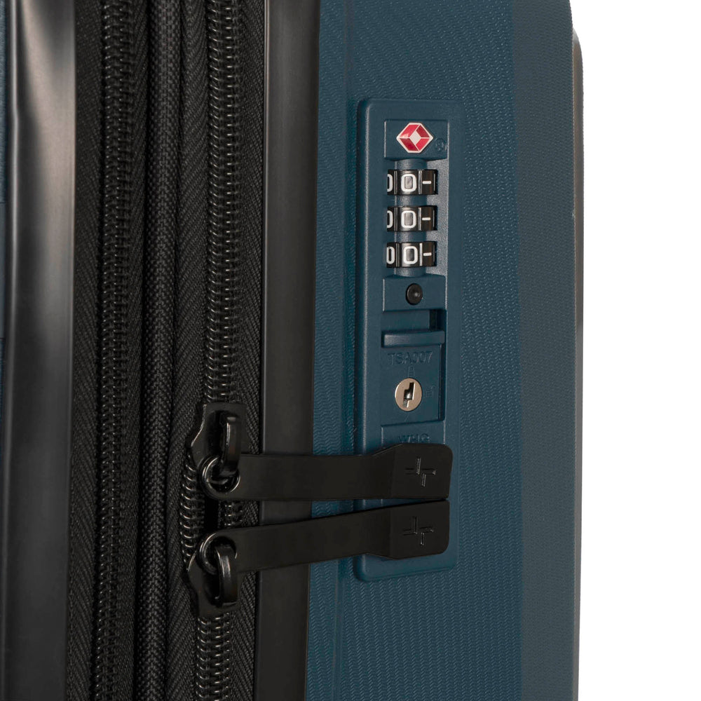 Close up of a navy luggage called Dynamo designed by Tracker showing its integrated TSA lock and rugged hard shell texture.