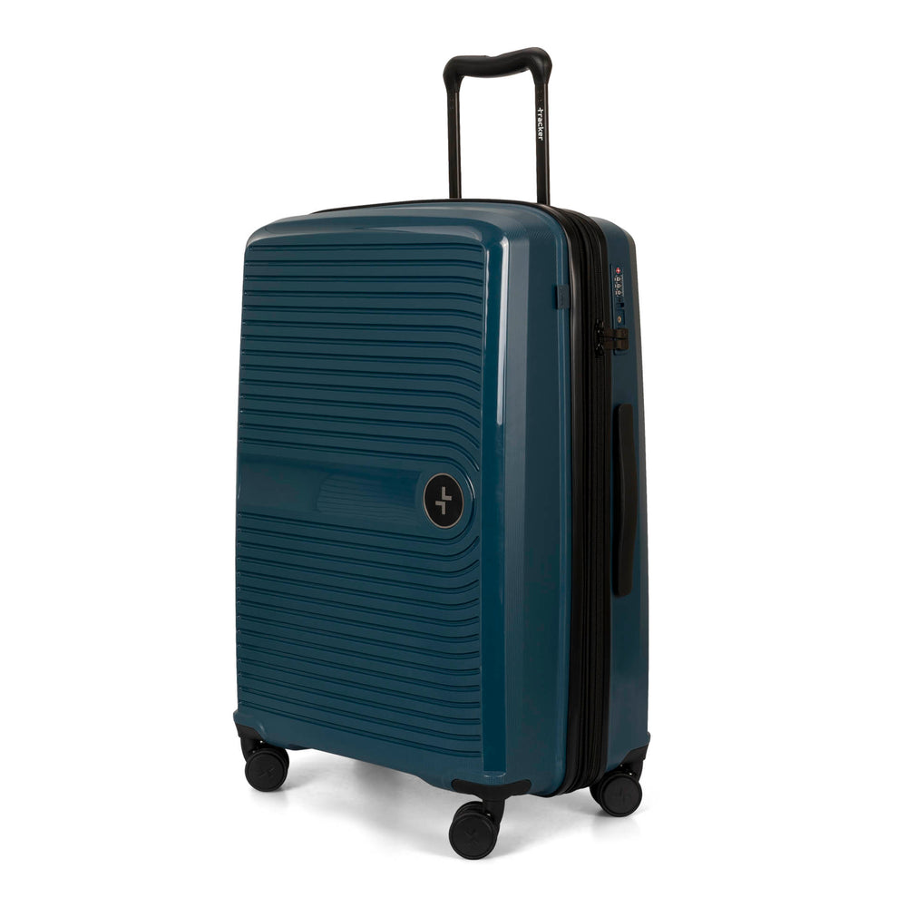 Angle view of a navy 25" luggage called Dynamo designed by Tracker showing its telescopic handle, lined-pattern shell, spinner wheels and tracker symbol embossed on the front.