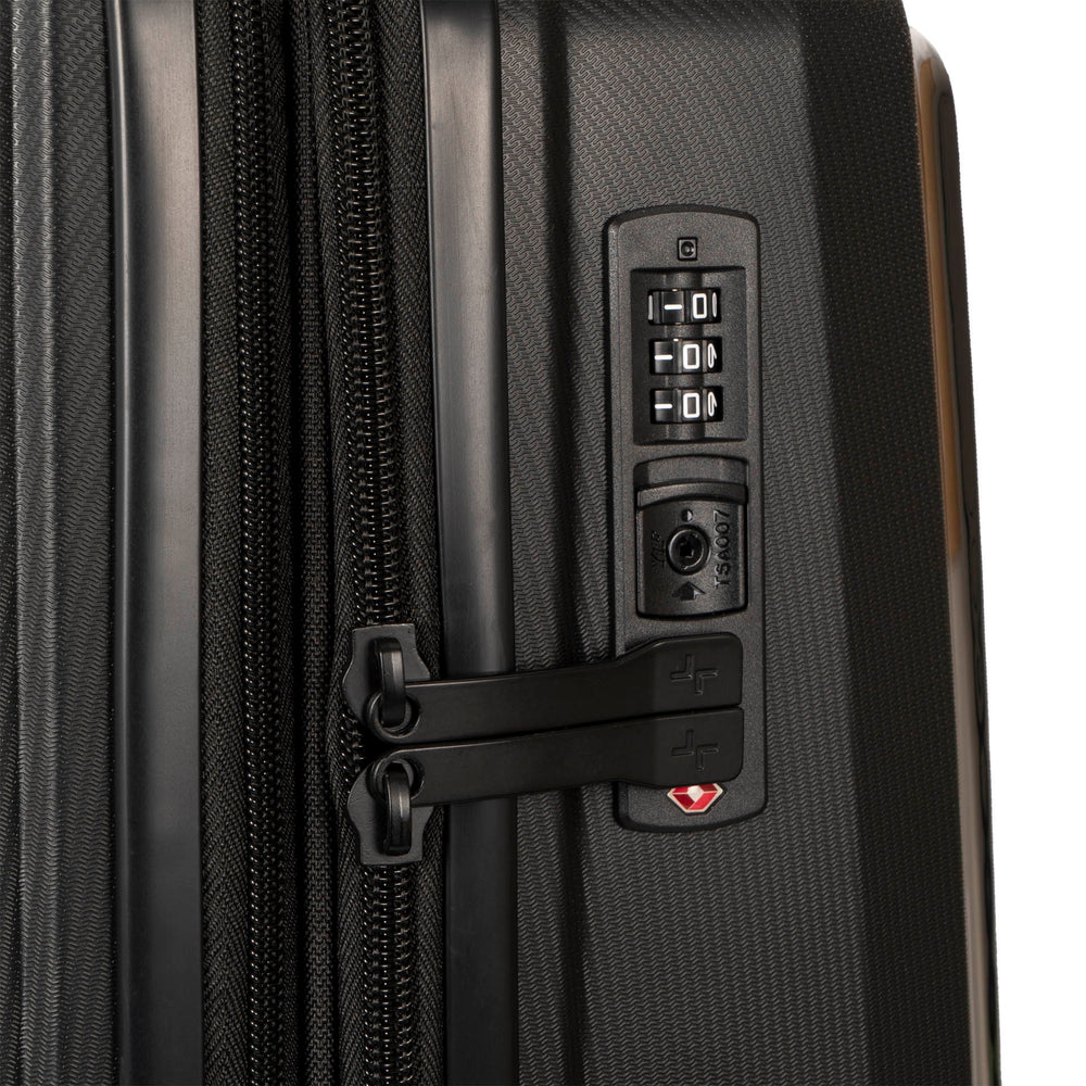 Close up of a black luggage called Dynamo designed by Tracker showing its integrated TSA lock and rugged hard shell texture