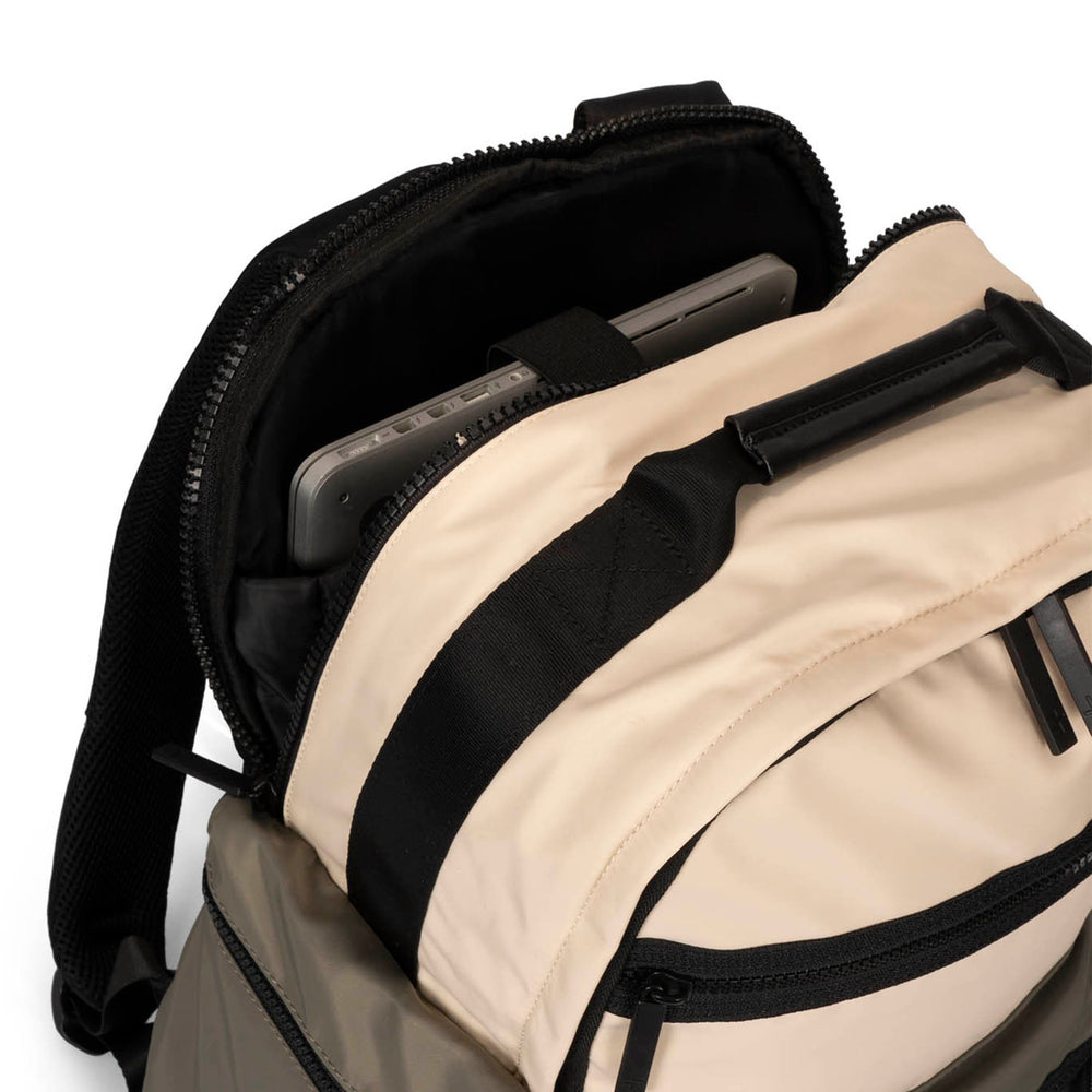 Close up view of a grey-green and beige backpack called Sutton by Tracker on white background, showcasing its interior laptop compartment, top handle and soft texture.