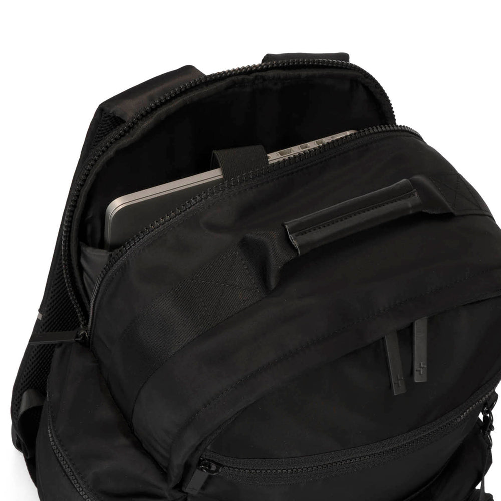 Close up view of a black backpack called Sutton by Tracker on white background, showcasing its interior laptop compartment, top handle and soft texture