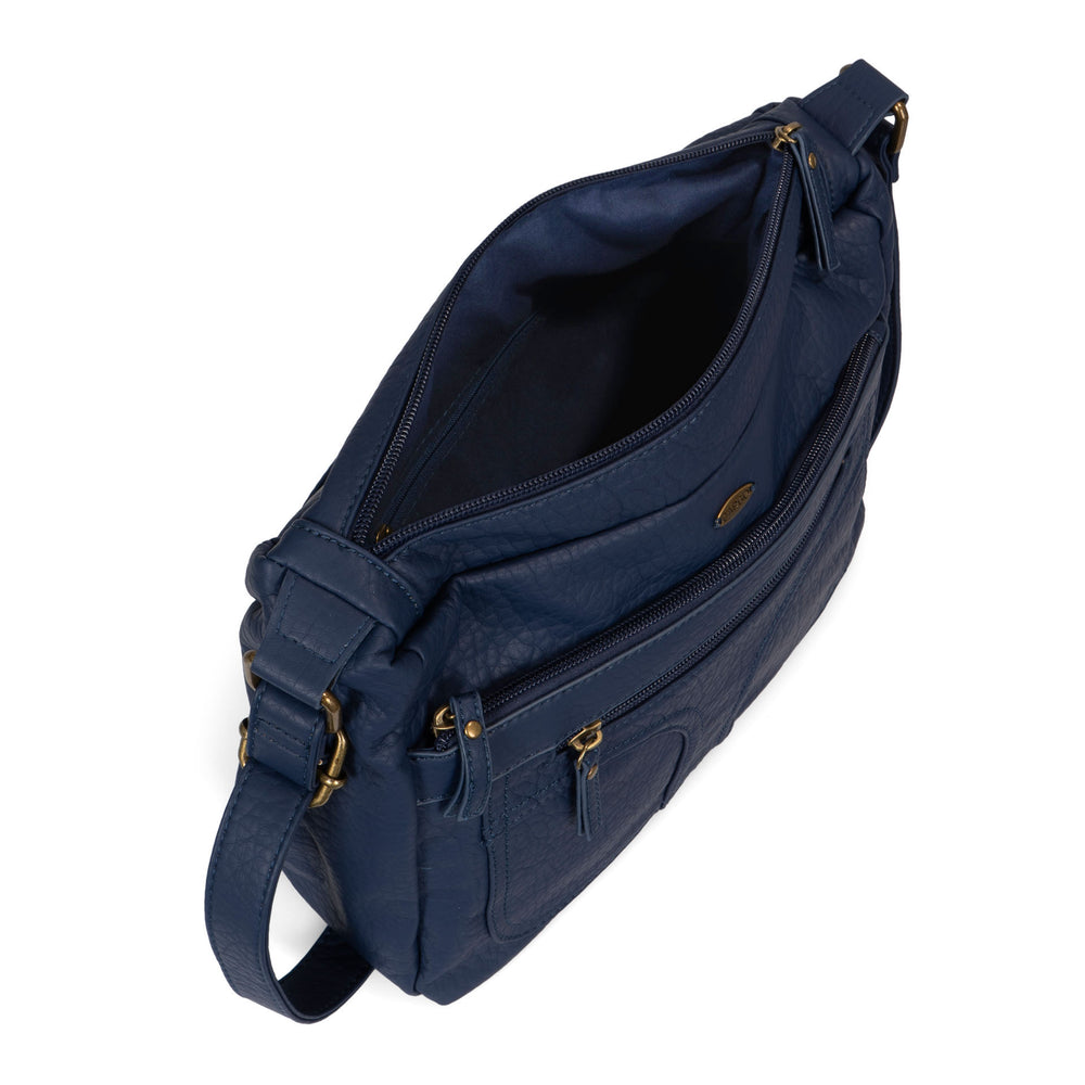 Angle view of a women's navy crossbody bag called Pebbled from the brand Cargo on a white background, showcasing its zippers, soft texture, and strap.