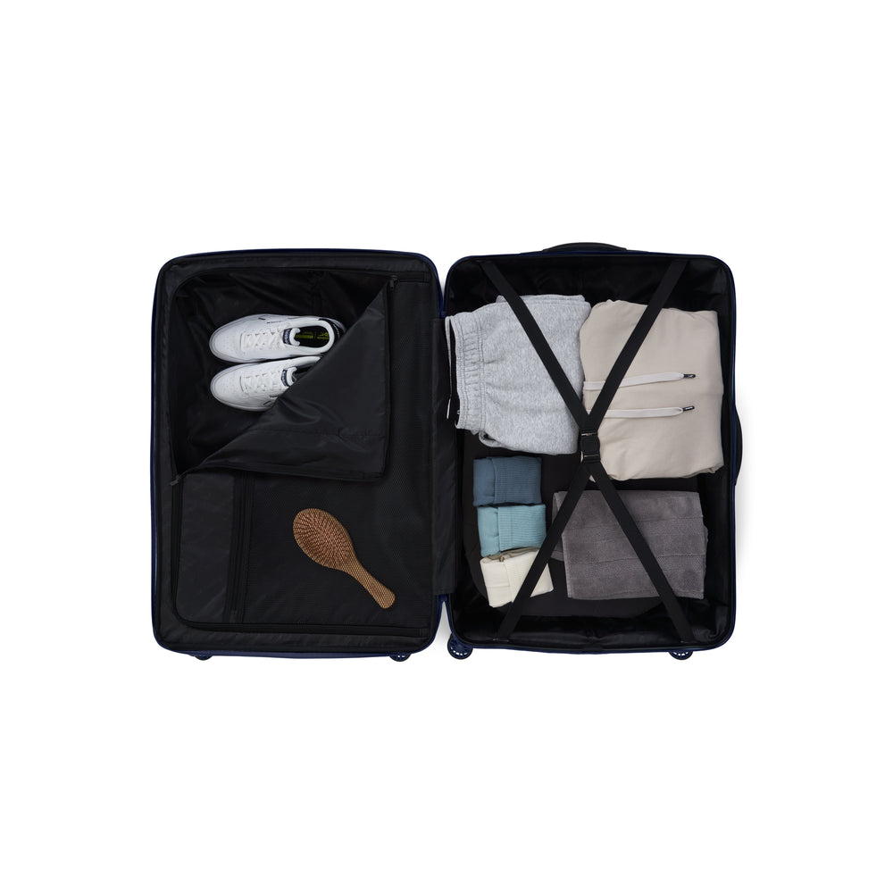 Black suitcase with clothes and a brush inside on a white background